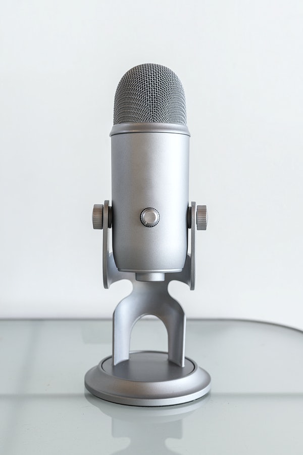 A microphone standing in a table with a white background to represent sharing one's voice