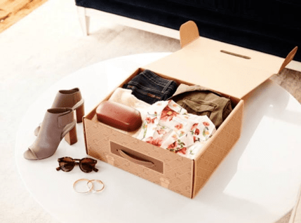 A shoe and clothing subscription box opened with the products being showned