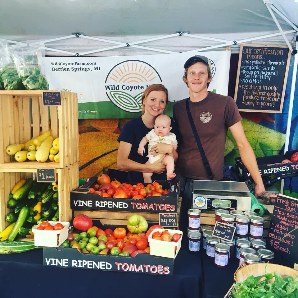 Wild Coyote Farms' Co-founders with their baby in their Chicago Farmers' Market station